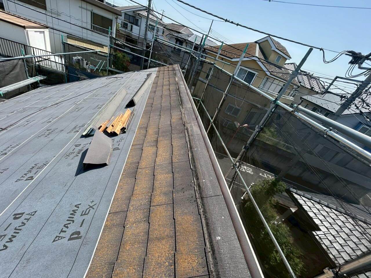 既存屋根に下葺き材を施工している途中の写真。