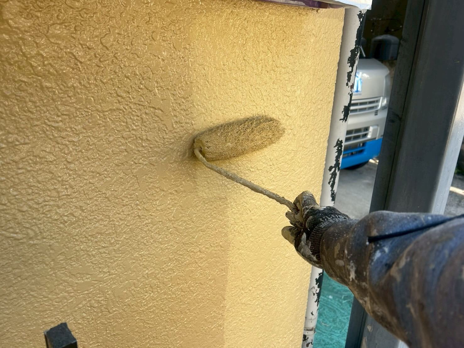 外壁に塗料を重ねて仕上げている工程。