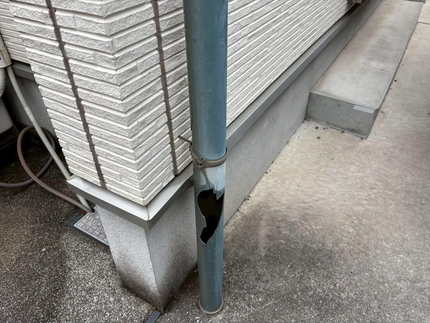 穴が開いて破損した住宅の縦樋